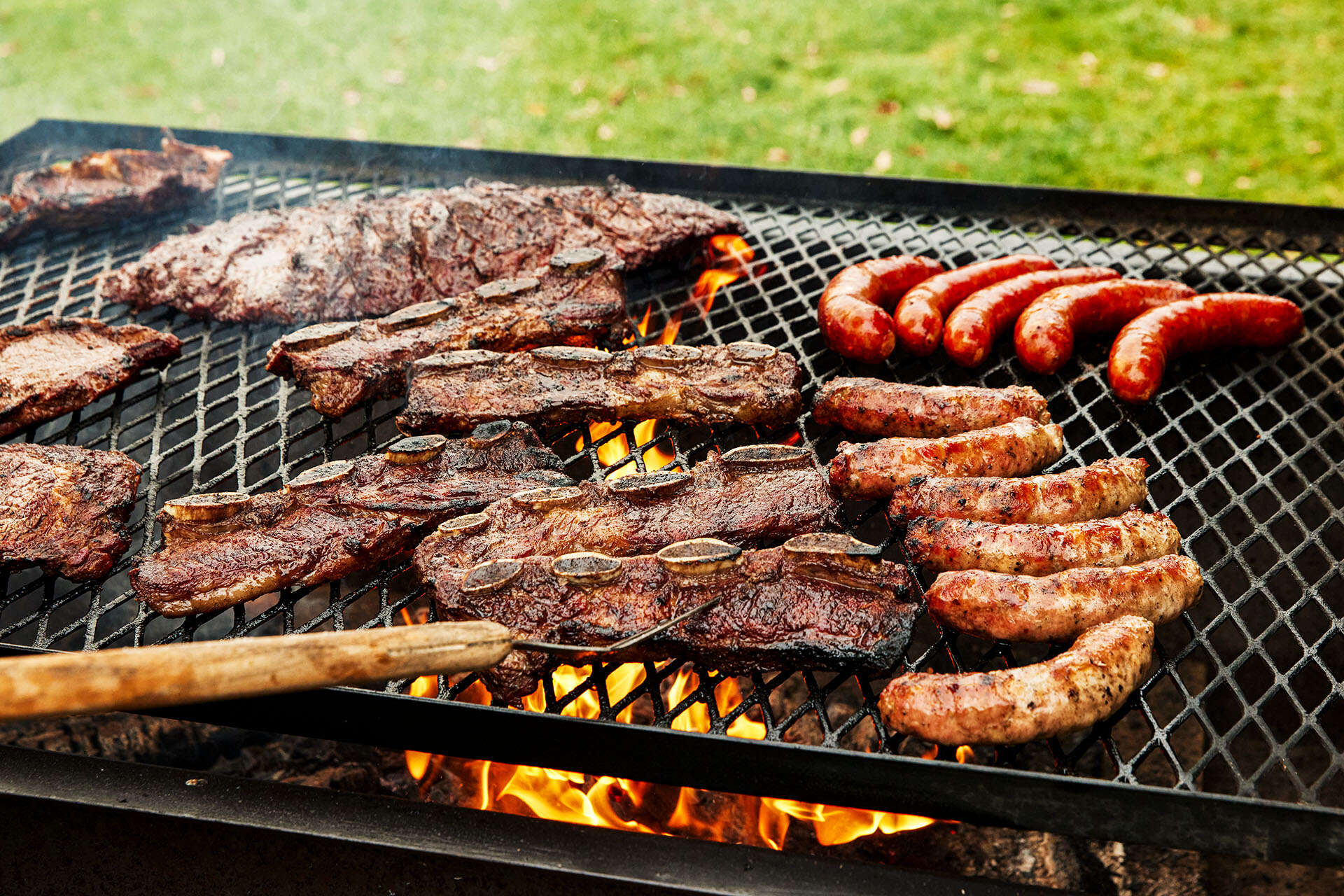 Meat and sausages grilling over an open flame